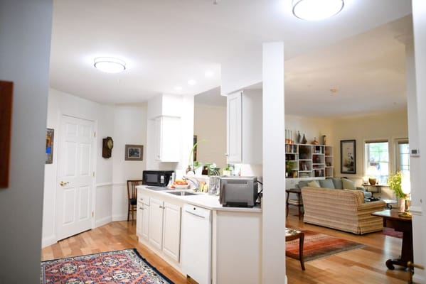 View of kitchen leading to living area in senior living facility