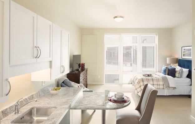 Interior view of a studio apartment featuring kitchenette and living area