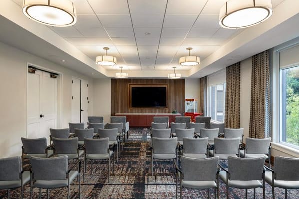 Empty conference room with chairs arranged and a television screen