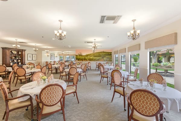 Spacious dining room with tables set for meals and scenic mural