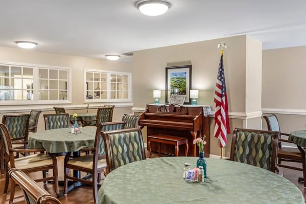 Interior view of a common area with tables and piano