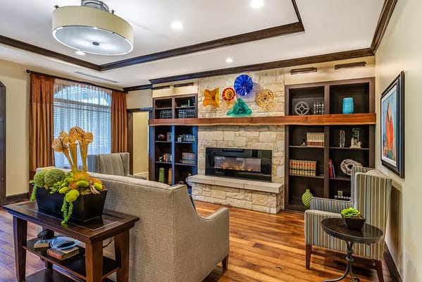Spacious common area with a fireplace and decorative shelves
