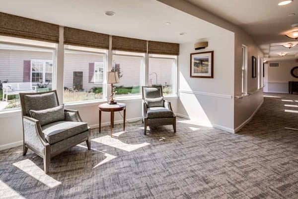 Cozy seating area with two chairs and a table by large windows