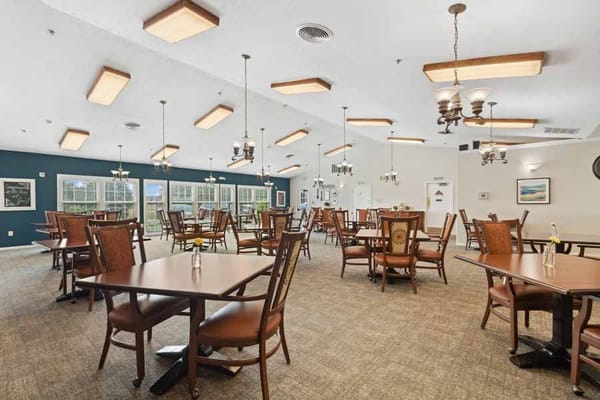 Spacious dining room with tables and chairs at a senior living facility