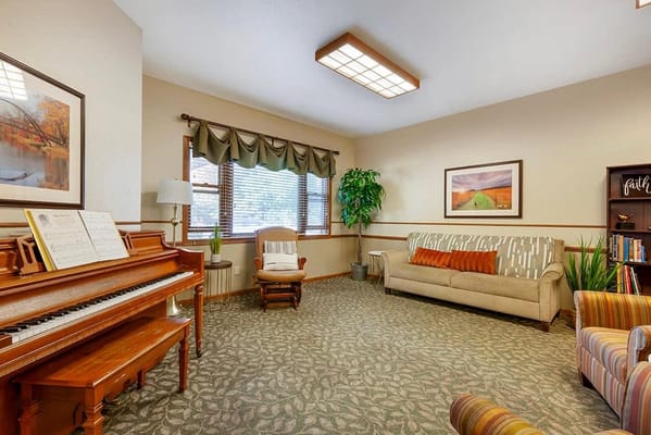 A cozy common area with a piano and seating