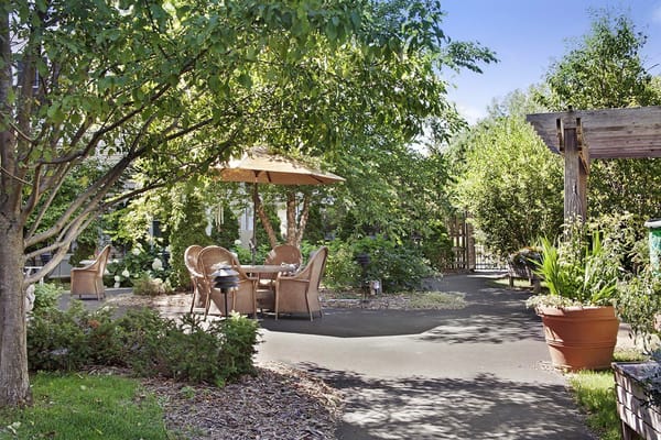 Cozy outdoor seating area with tables and chairs under trees