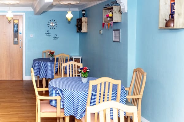 Bright dining area with checkered tablecloths and wooden chairs