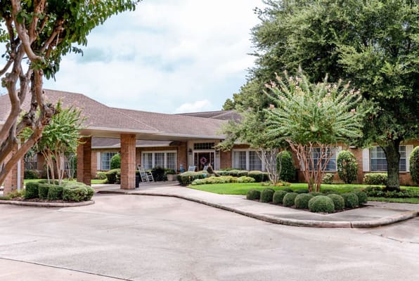 Exterior view of a senior living facility with landscaped garden