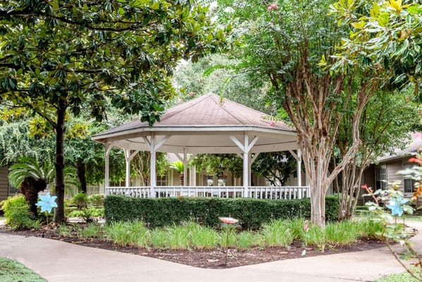Gazeebo surrounded by greenery in a serene garden