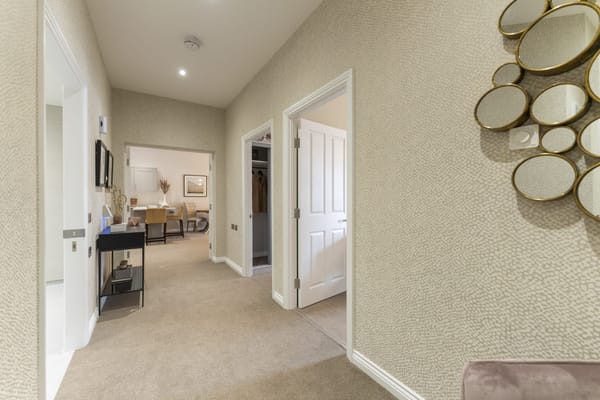A well-decorated hallway with doors and a stylish mirror.