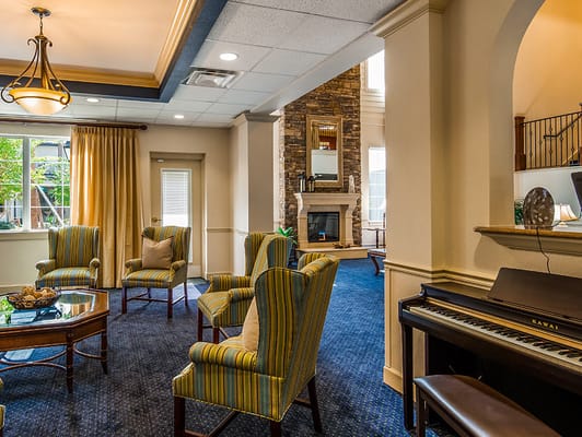 Lounge area with seating and piano at The Windsor of Gainesville