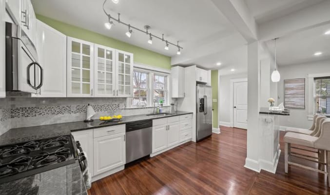 Bright kitchen with modern appliances and wooden flooring