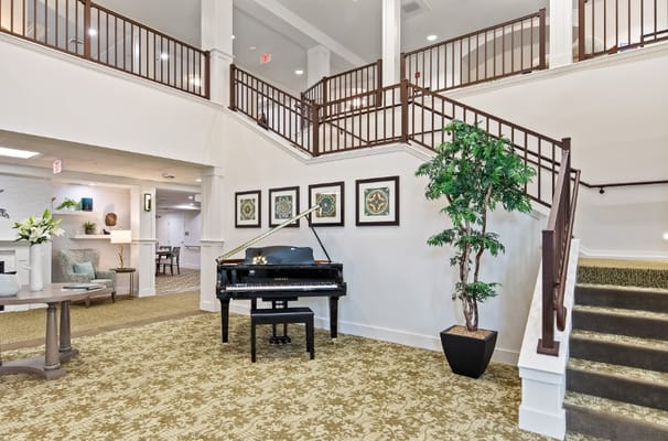 Lobby featuring a grand piano and decorative staircase