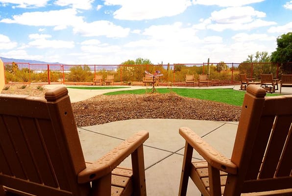 View of a landscaped patio with rocking chairs.