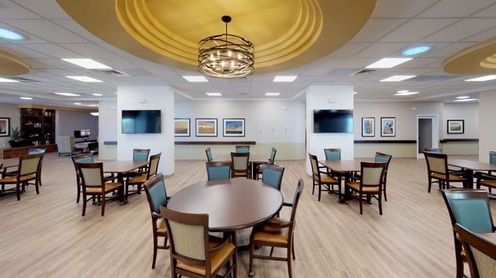 Spacious dining room with tables and chairs at Via Elegante.