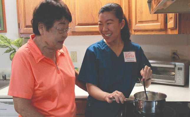 Staff member cooking with a resident in the kitchen