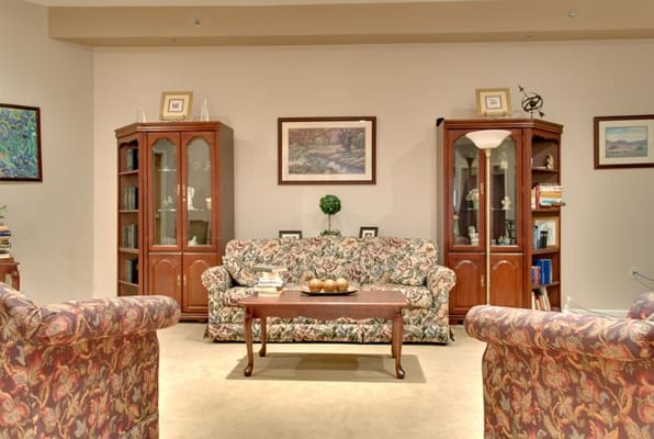 Comfortable living room with floral sofas and wooden furniture