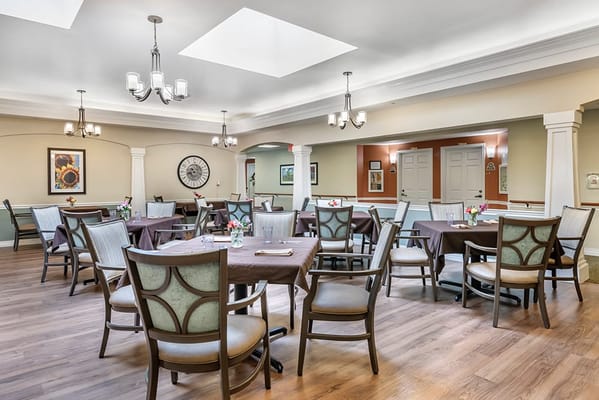 Bright dining room with tables set for residents