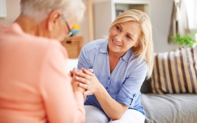Caregiver interacting with a senior resident in a cozy room