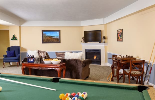 Lounge area featuring a pool table, comfortable seating and a fireplace