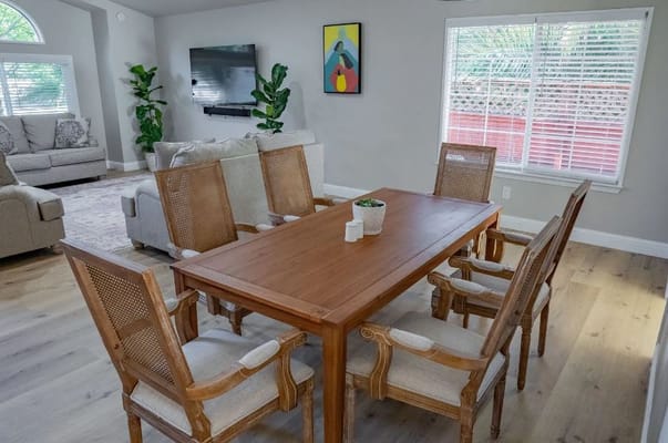 Dining area with wooden table and chairs in a bright room