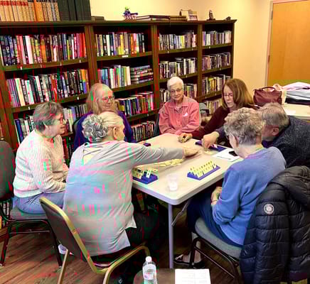 Residents playing a game in a warm, inviting activity room