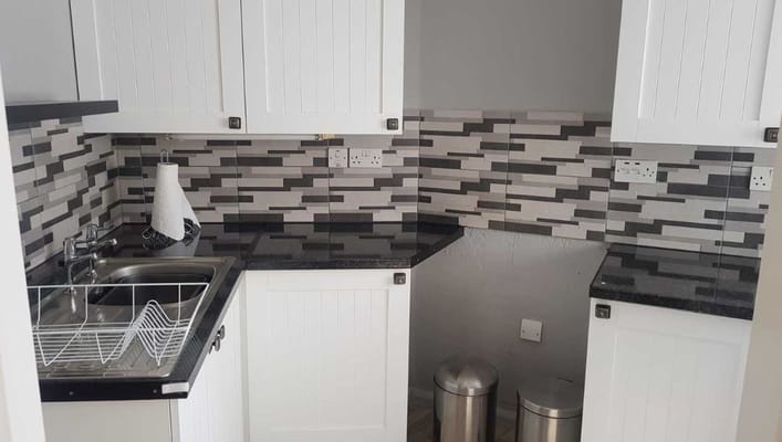 Modern kitchen with white cabinets and black countertops