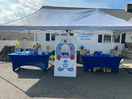 A promotional tent setup for In-Home Angels