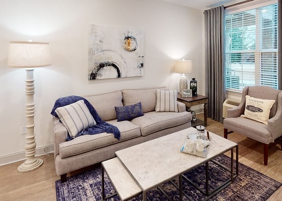 A cozy living room area with a couch and lamp