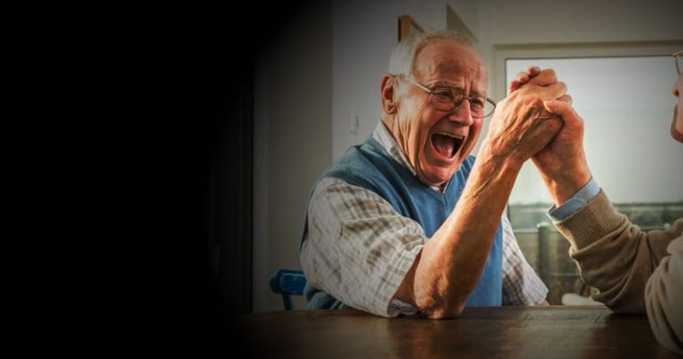Two seniors engaged in an arm wrestling match