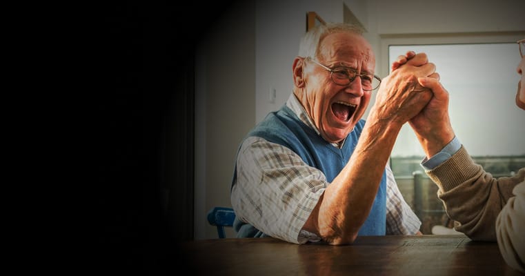 Two seniors engaged in an arm wrestling match