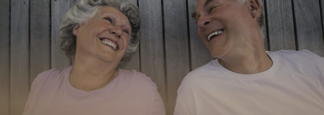 Two seniors laughing together outdoors