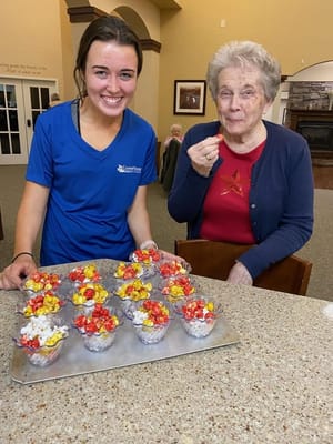 Staff member serving popcorn treats to a resident