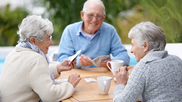 Residents enjoying a card game at a table