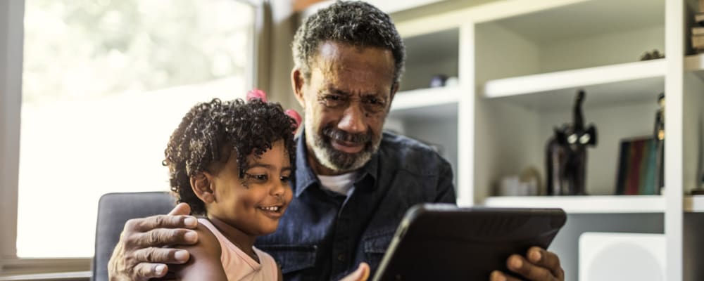 Elderly man and young girl using a tablet together