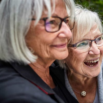 Two smiling senior women enjoying a moment together