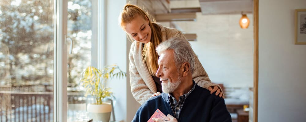 A caregiver interacting with a senior resident in a bright space
