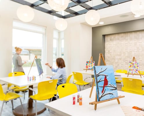 Residents engaged in a painting activity in a bright room
