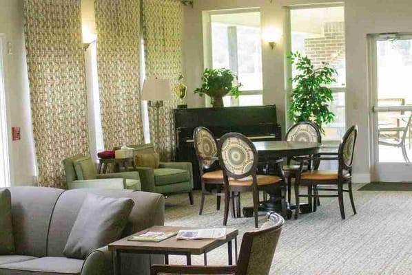 Common area with seating and piano in a senior living facility
