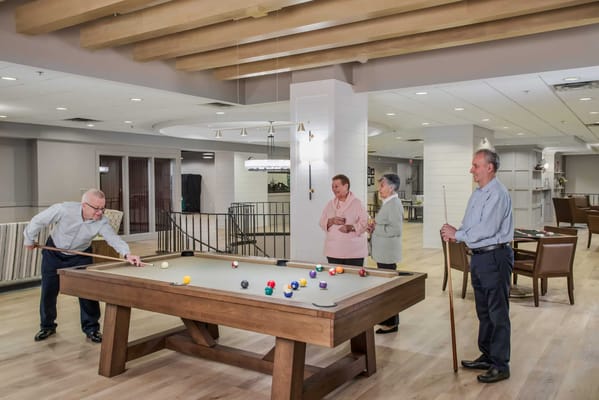 Residents enjoying a game of billiards in a common area