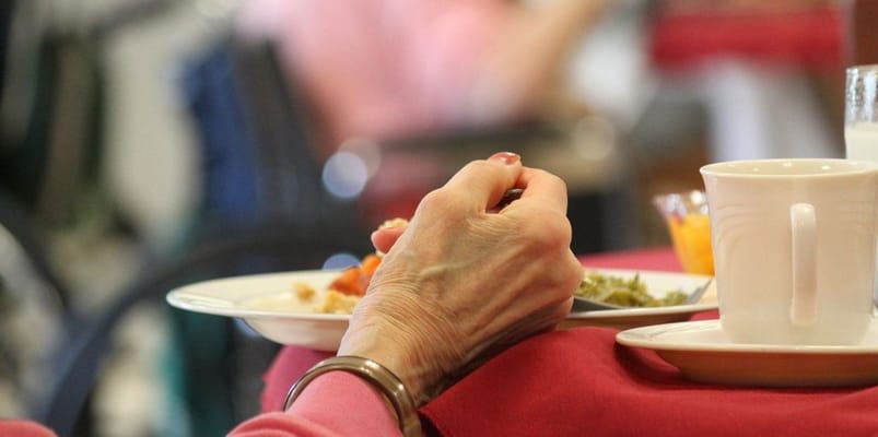 A resident enjoying a meal at the dining area