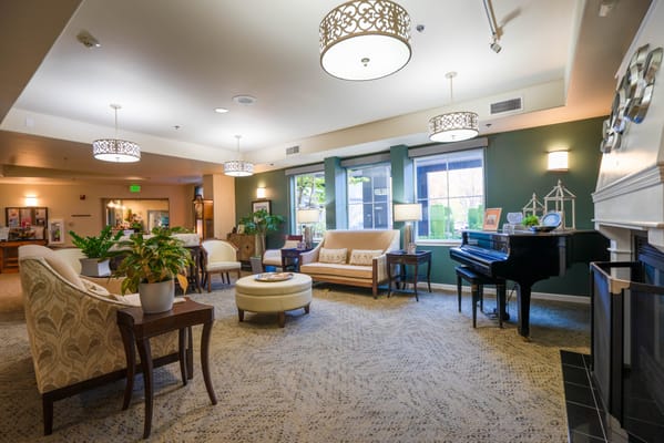 Bright common area with seating and a piano