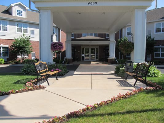 Entrance of a senior living facility with outdoor seating