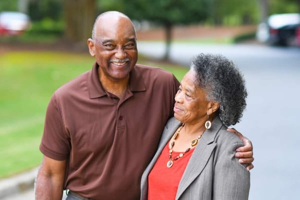 Two residents smiling together in a garden area