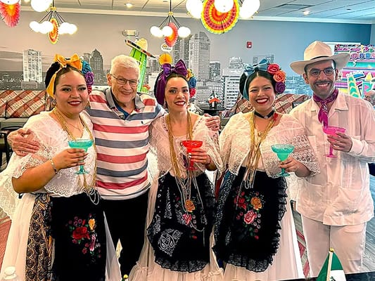 Residents celebrating with performers in colorful attire