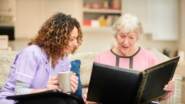Caregiver and resident enjoying a photo album together