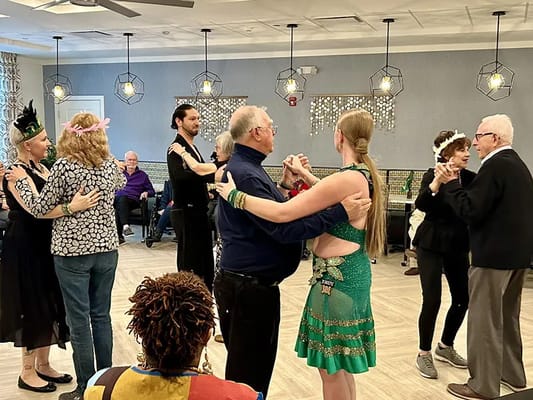Residents and staff dancing in a community activity