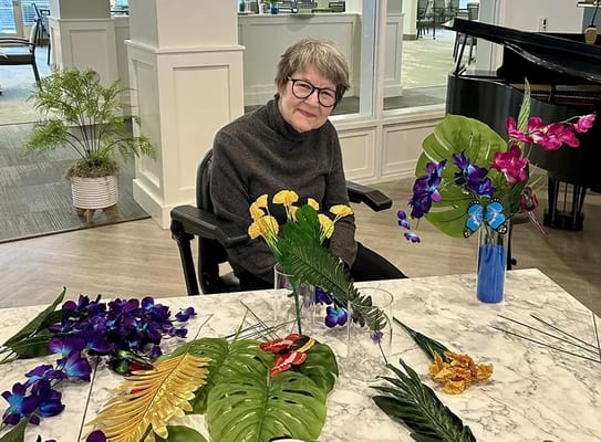 A resident participating in a floral arrangement activity