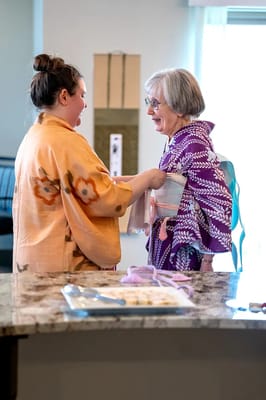 A caregiver assisting a senior resident in a vibrant activity room