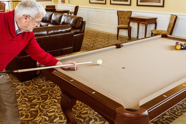 Resident playing billiards in a common area